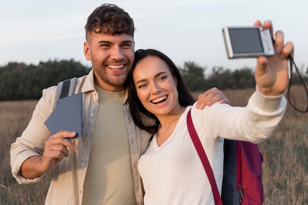 Kostenloses Foto mittleres schuss glückliches paar, das selfies nimmt