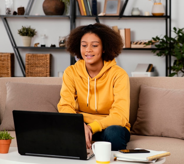 Mittleres Schuss Smiley-Mädchen auf der Couch