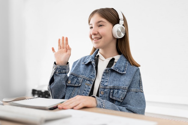 Kostenloses Foto mittleres schuss smiley-mädchen mit der hand nach oben