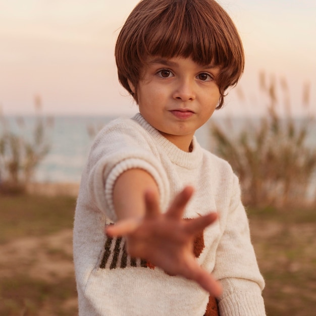 Kostenloses Foto mittleres schuss süßes kind am meer