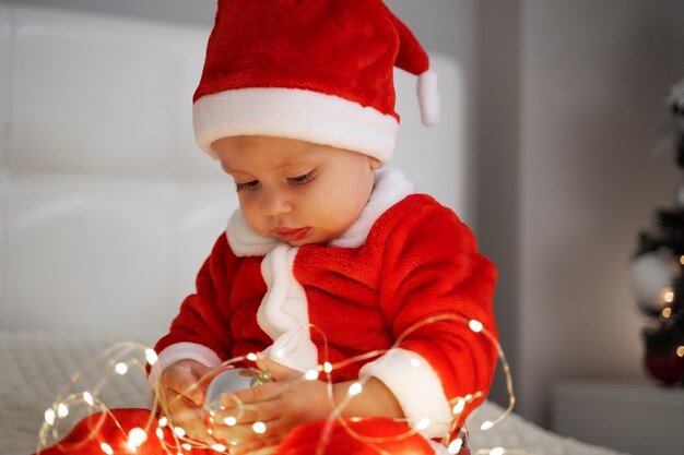 Mittleres schussbaby, das mit weihnachtslichtern spielt