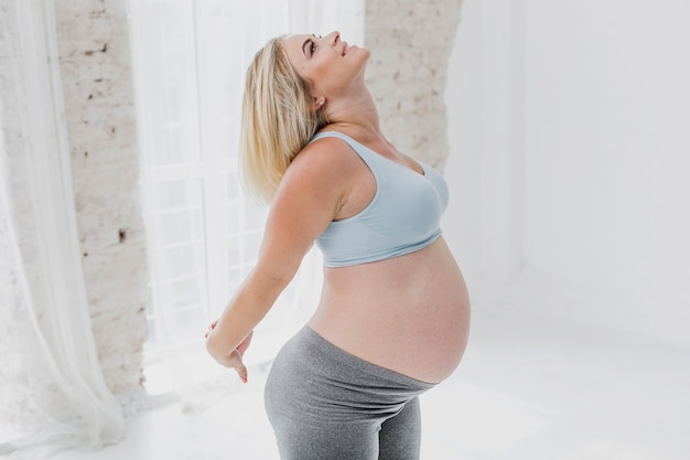 Kostenloses Foto mittleres schussglückliches trainieren der schwangeren frau