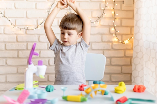 Kostenloses Foto mittleres schusskind auf stuhl