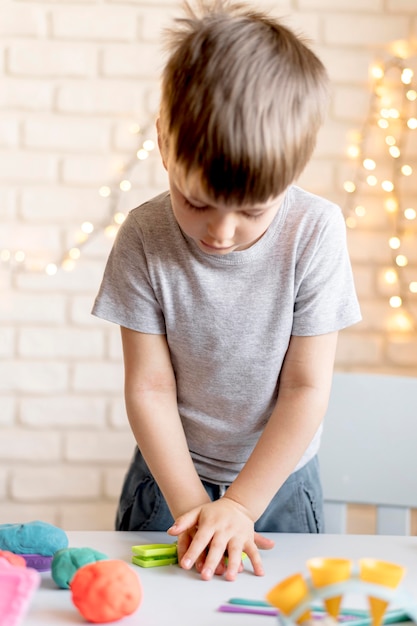 Kostenloses Foto mittleres schusskind, das drinnen spielt