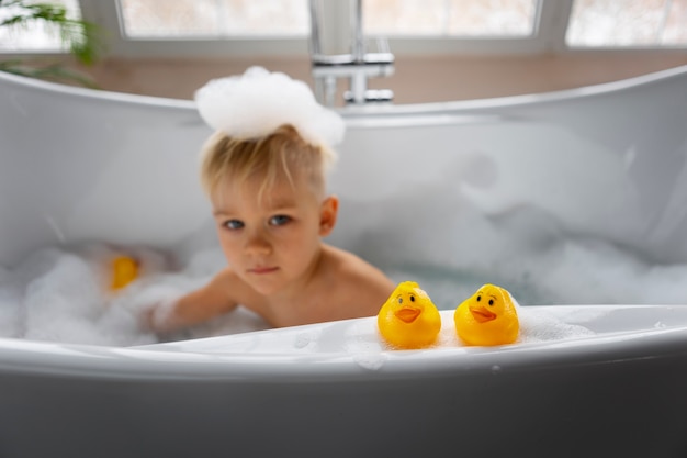 Kostenloses Foto mittleres schusskind, das in der badewanne spielt