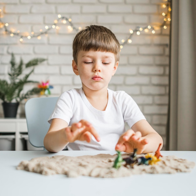 Mittleres Schusskind, das mit Dinosaurier spielt