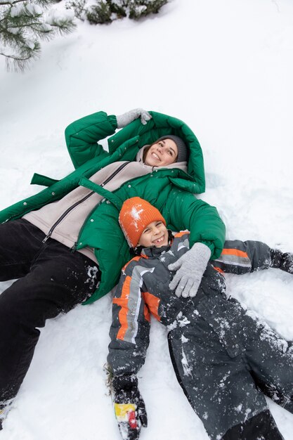 Mittleres Schusskind und -frau, die in Schnee legen