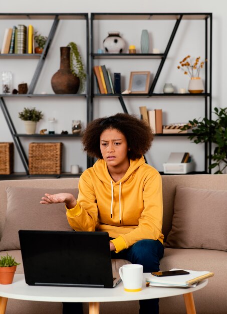 Mittleres Schussmädchen, das auf Couch sitzt