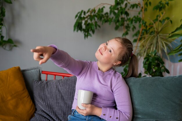 Mittleres Schussmädchen, das auf Couch sitzt