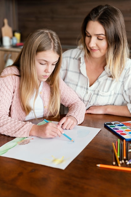 Kostenloses Foto mittleres schussmädchen, das auf papier zeichnet