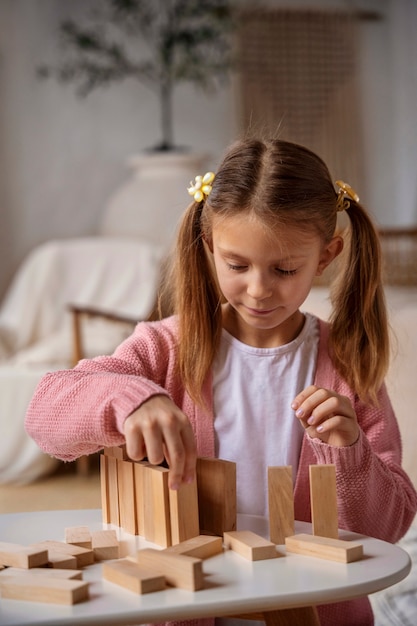 Kostenloses Foto mittleres schussmädchen, das gedächtnisspiel spielt