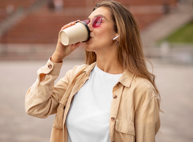 Kostenloses Foto mittleres schussmädchen, das kaffee trinkt