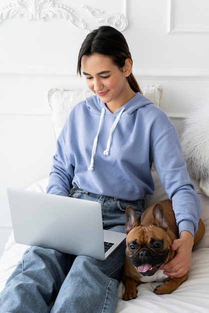 Kostenloses Foto mittleres schussmädchen, das laptop hält