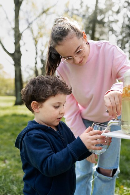 Mittleres Schussmädchen, das Limonade gießt