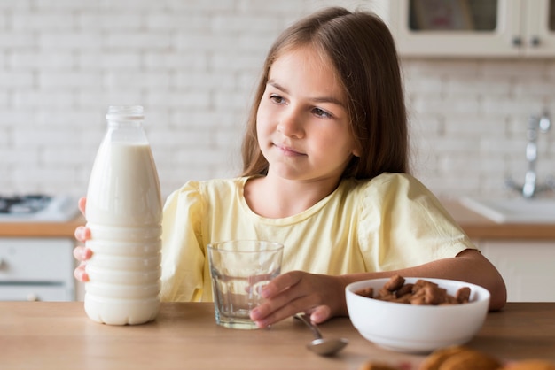 Mittleres Schussmädchen, das Milchflasche hält