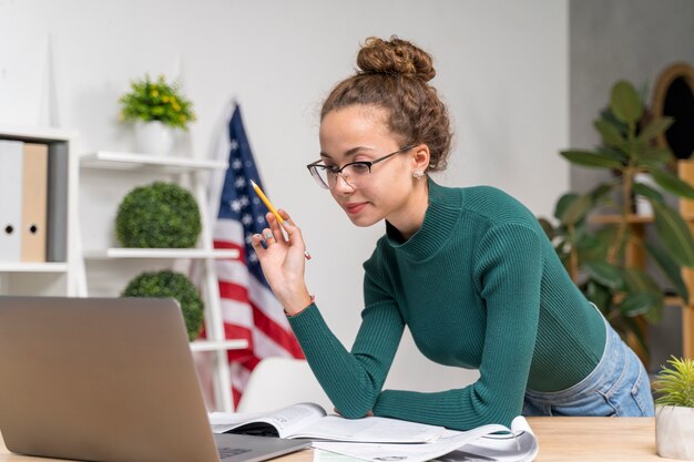 Mittleres Schussmädchen, das mit Laptop studiert