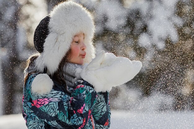 Mittleres Schussmädchen, das mit Schnee spielt