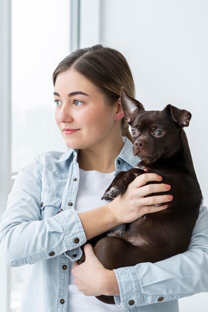 Mittleres Schussmädchen, das niedlichen Hund hält