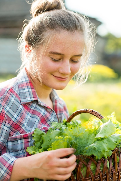 Mittleres Schussmädchen, das Salatkorb hält