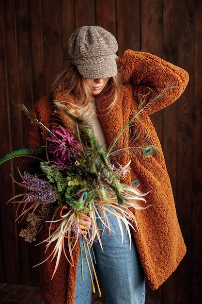 Kostenloses Foto mittleres schussmädchen mit der blumen- und hutaufstellung