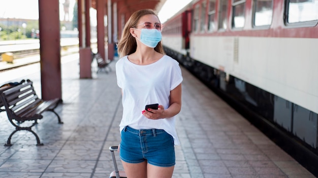 Mittleres Schussmädchen mit Maske, die entlang Zug geht