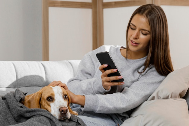 Kostenloses Foto mittleres schussmädchen mit telefon und hund