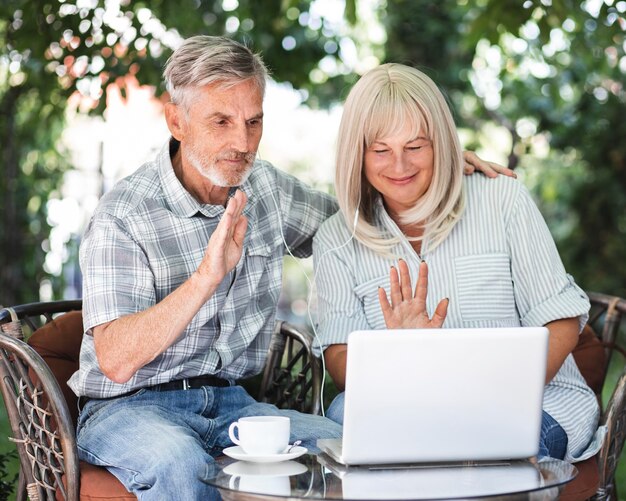 Mittleres Schusspaar, das auf Laptop winkt