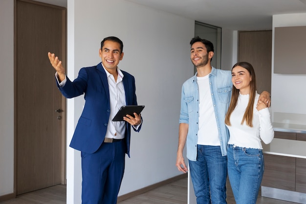 Mittleres Schusspaar, das mit Immobilienmakler spricht