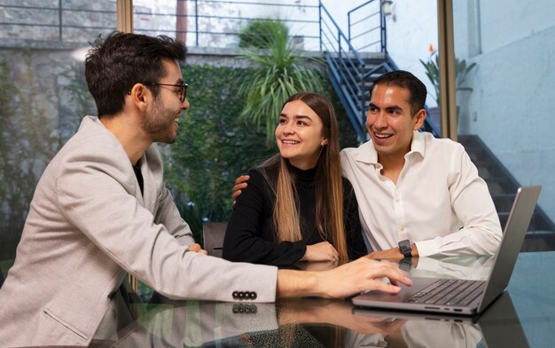 Mittleres Schusspaar, das mit Immobilienmakler spricht
