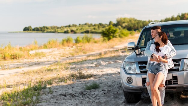 Mittleres Schusspaar, das nahe Auto umarmt