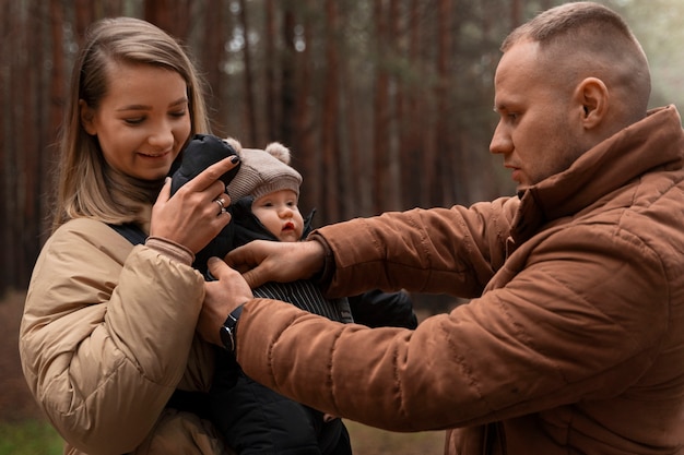 Kostenloses Foto mittleres schusspaar mit baby draußen