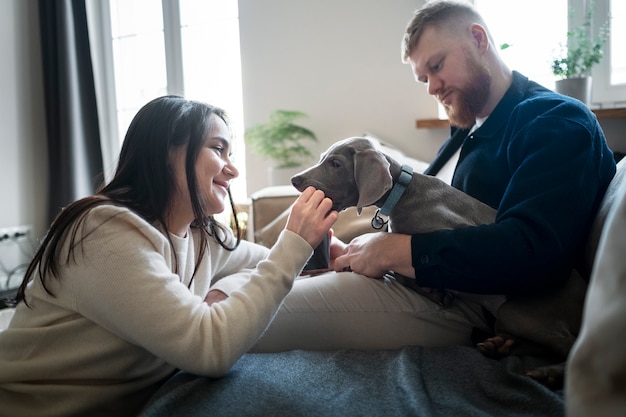 Kostenloses Foto mittleres schusspaar zu hause mit hund