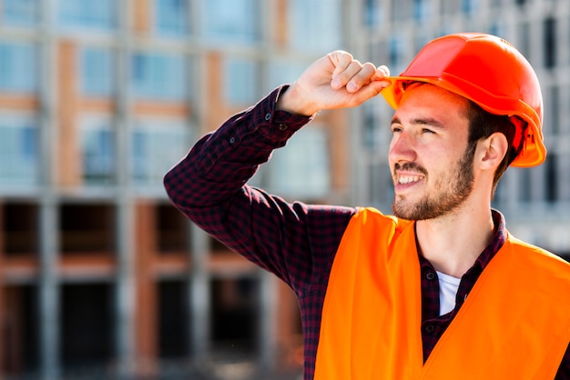 Mittleres Schussporträt des Bauarbeiters weg schauend