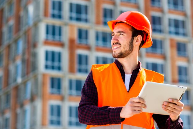 Mittleres Schussporträt des Bauingenieurs Tablette halten