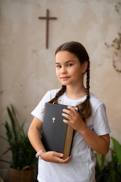 Kostenloses Foto mittleres schusssmileymädchen, das bibel hält