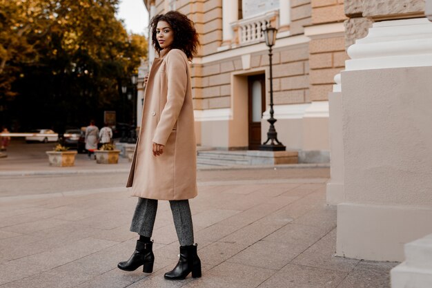 Mode in voller Länge Bild der eleganten schwarzen Frau in stilvollen Luxus beige Mantel und Samtpullover