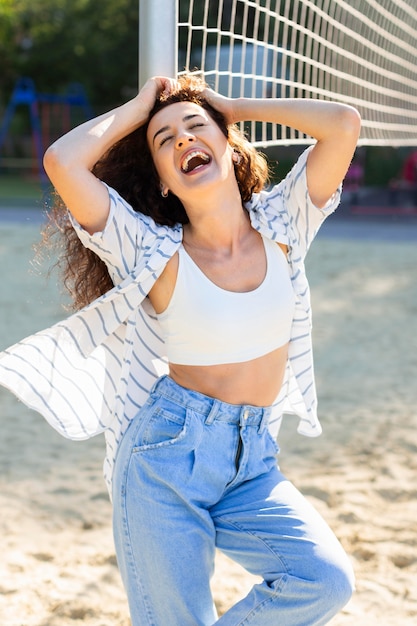 Mode junge Frau, die neben einem Volleyballfeld aufwirft