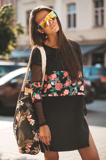 Mode lustige Glamour stilvolle sexy lächelnde schöne junge Frau Modell in schwarzen Hipster Sommerkleidung in der Straße nach dem Einkaufen