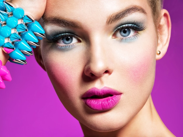Mode-modell mit hellem make-up und kreativer frisur frau mit mode-make-up nahaufnahmeporträt