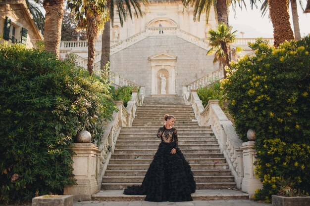 Mode schöne Frau im schwarzen Luxuskleid im Freien