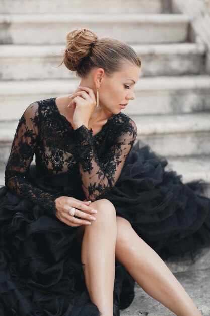 Mode schöne Frau im schwarzen Luxuskleid im Freien