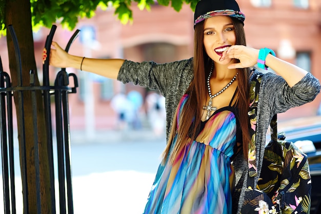 Kostenloses Foto mode stilvolle schöne junge brünette frau modell im sommer hipster bunte freizeitkleidung posiert auf der straße