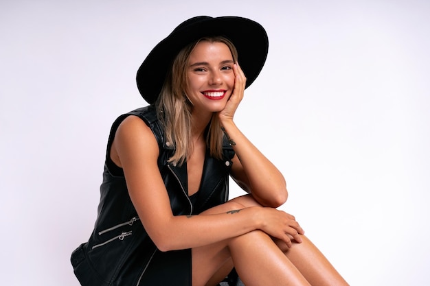 Mode-Studio-Porträt einer jungen Bloggerin mit total schwarzem Outfit, weißem, isoliertem Hintergrund