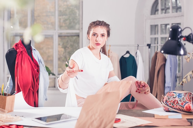 Kostenloses Foto modedesigner, die im studio arbeiten, das auf dem schreibtisch sitzt