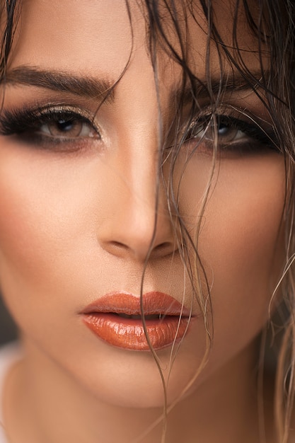 Model im abendlichen Make-up mit rauchigen Augen und sonnengebräunten Tönen