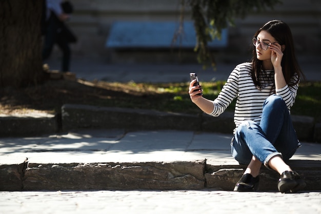 Model mitten in der Stadt mit Handy