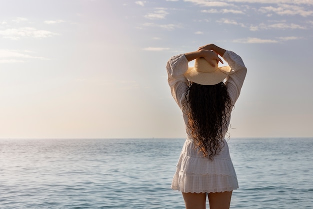 Kostenloses Foto modell der hinteren ansicht, das am strand aufwirft