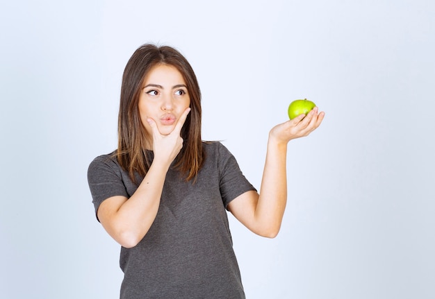 Modell der jungen Frau, das einen grünen Apfel hält.