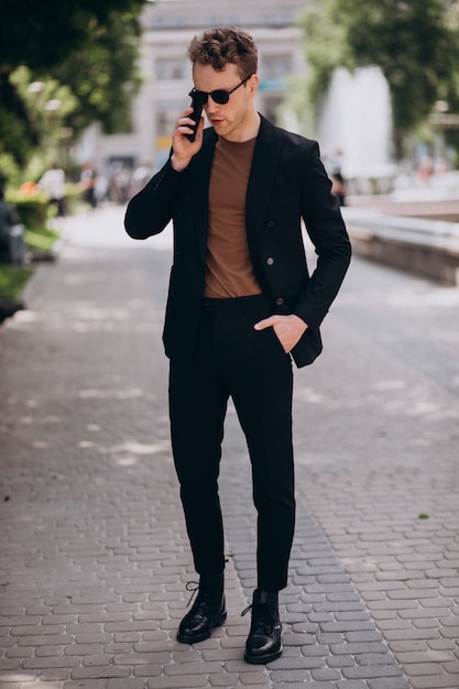 Modell des jungen Mannes, das Telefon verwendet