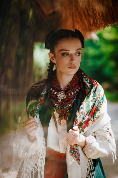Modell in einem ukrainischen Kleid wirft im Park auf